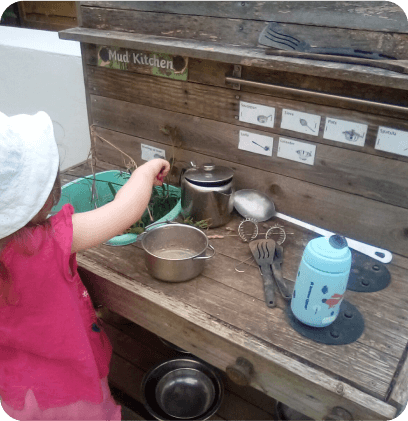 A child using the outdoor kitchen